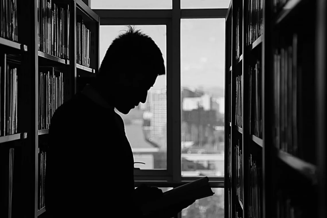 sort hvid foto af mand på bibliotek som i mentalisering