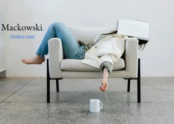 Kvinde på sofa med papirblok over hovedet prokrastinering.