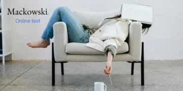 Kvinde på sofa med papirblok over hovedet prokrastinering.