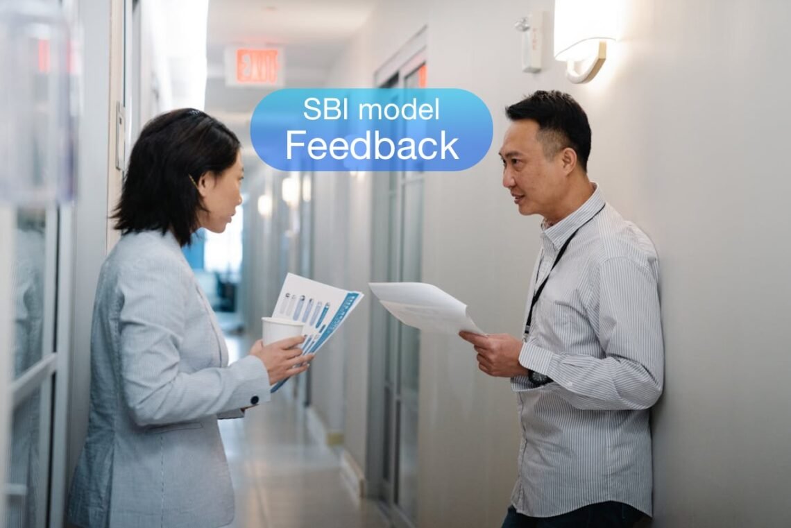 SBI model 2 mennesker i en kontorgang deler feedback med hinanden.