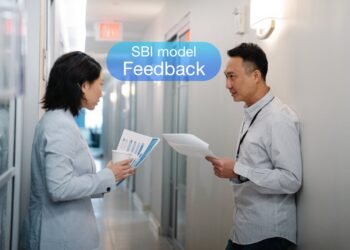 SBI model 2 mennesker i en kontorgang deler feedback med hinanden.