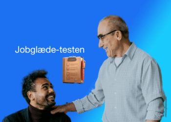 Jobglæde-test chef lægger rolig hånd på medarbejder og smiler V2.1