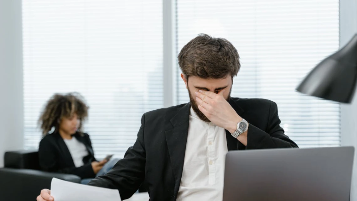 Udbrændthed vs stress mand sidder på kontor og ser udbrændt ud